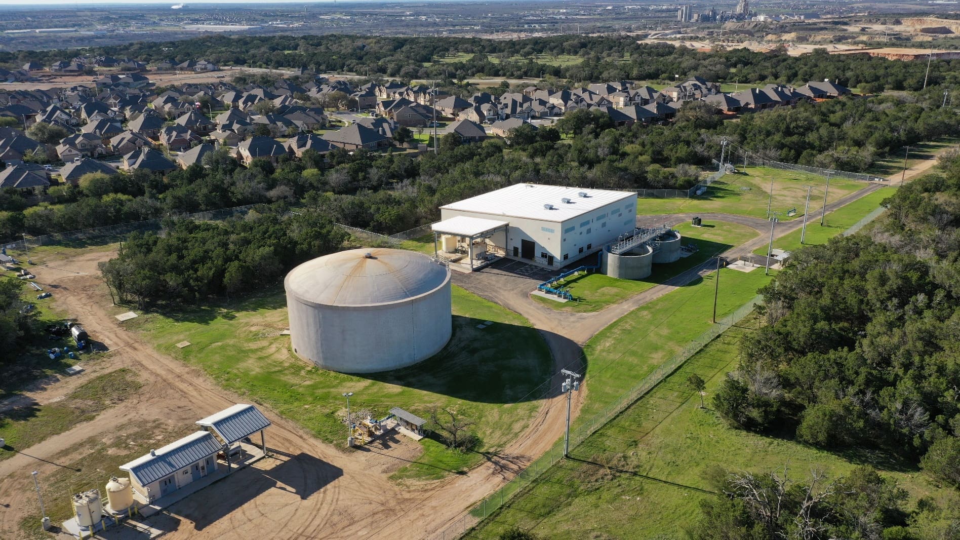An aerial view of a large water tank in the middle of a field.