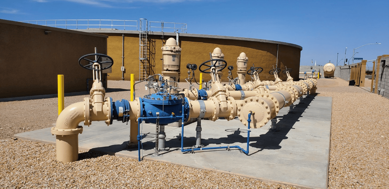 A group of pipes and valves in front of a building.